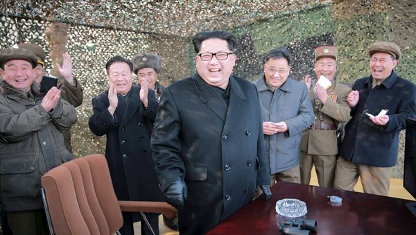 North Korean leader Kim Jung Un smiles after a successful test of a new rocket launch system. - Sputnik International