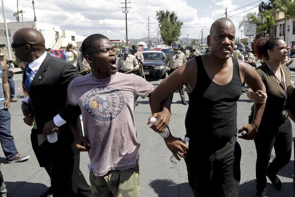 People link arms to move away from a line of police during a protest Wednesday, Sept. 28, 2016, in El Cajon, Calif. Dozens of demonstrators on Wednesday protested the killing of a black man shot by an officer after authorities said the man pulled an object from a pocket, pointed it and assumed a shooting stance. People link arms to move away from a line of police during a protest Wednesday, Sept. 28, 2016, in El Cajon, Calif. Dozens of demonstrators on Wednesday protested the killing of a black man shot by an officer after authorities said the man pulled an object from a pocket, pointed it and assumed a shooting stance. - Sputnik International