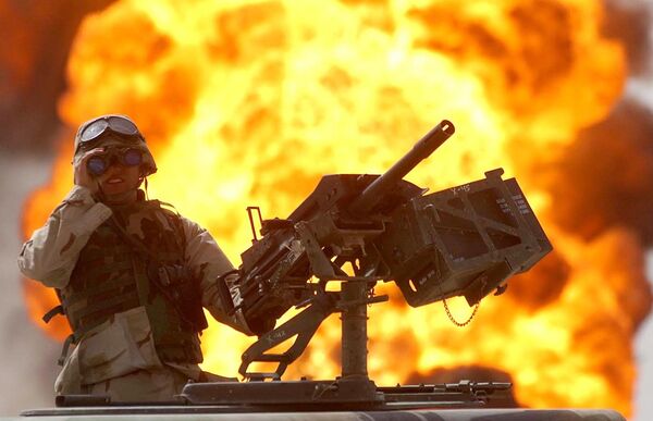 A US soldier looks through a pair of binoculars as a fire in the Rumeila oil field burns in the background in southern of Iraq, Sunday, March 30, 2003. A US soldier looks through a pair of binoculars as a fire in the Rumeila oil field burns in the background in southern of Iraq, Sunday, March 30, 2003. - Sputnik International