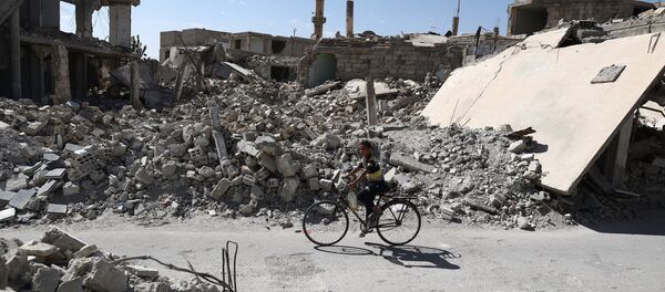 A Syrian boy rides a bicycle past destroyed buildings in the rebel-held town of Douma, on the eastern outskirts of the capital Damascus on September 25, 2016 A Syrian boy rides a bicycle past destroyed buildings in the rebel-held town of Douma, on the eastern outskirts of the capital Damascus on September 25, 2016 - Sputnik International