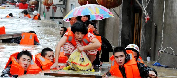 Rescuers evacuate residents through floodwaters brought by typhoon Megi in Ningde, eastern China's Fujian province on September 28, 2016 - Sputnik International