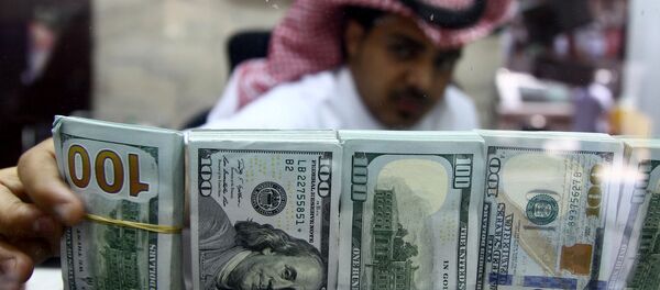 A Saudi money changer, pictured through a glass, arranges U.S banknotes at a currency exchange shop in Riyadh, Saudi Arabia September 29, 2016 A Saudi money changer, pictured through a glass, arranges U.S banknotes at a currency exchange shop in Riyadh, Saudi Arabia September 29, 2016 - Sputnik International