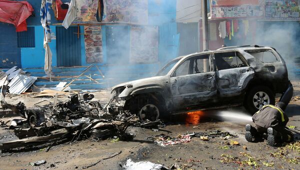 A firefighter tries to extinguish fire from the wreckage of a burning vehicle following an attack on a restaurant by the Somali Islamist group al Shabaab in the capital Mogadishu, Somalia, October 1, 2016 - Sputnik International