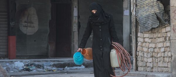 A woman walks in a residential area of Aleppo, a city divided by a front line (File) A woman walks in a residential area of Aleppo, a city divided by a front line (File) - Sputnik International