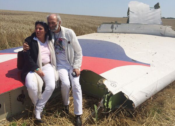Jerzy Dyczynski and Angela Rudhart-Dyczynski whose daughter, 25-year-old Fatima, was a passenger on Malaysia Airlines flight MH17, sit on part of the wreckage of the crashed aircraft in Hrabove, Ukraine, Saturday, July 26, 2014 Jerzy Dyczynski and Angela Rudhart-Dyczynski whose daughter, 25-year-old Fatima, was a passenger on Malaysia Airlines flight MH17, sit on part of the wreckage of the crashed aircraft in Hrabove, Ukraine, Saturday, July 26, 2014 - Sputnik International
