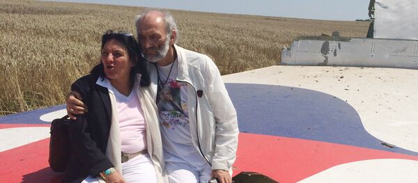 Jerzy Dyczynski and Angela Rudhart-Dyczynski whose daughter, 25-year-old Fatima, was a passenger on Malaysia Airlines flight MH17, sit on part of the wreckage of the crashed aircraft in Hrabove, Ukraine, Saturday, July 26, 2014 Jerzy Dyczynski and Angela Rudhart-Dyczynski whose daughter, 25-year-old Fatima, was a passenger on Malaysia Airlines flight MH17, sit on part of the wreckage of the crashed aircraft in Hrabove, Ukraine, Saturday, July 26, 2014 - Sputnik International
