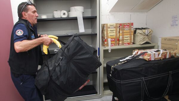 A custom officer of Ax-les-Thermes carries a bag of cigarettes seized during an operation monitoring the smuggling of cigarettes from the Principality of Andorra in the Pyrenees mountains on July 17, 2013 - Sputnik International