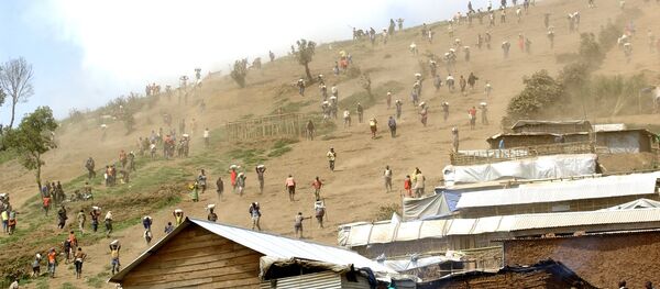 People carry bags of cassiterite (tin ore), coltan, which is used in mobile telephones and computers, and manganese down a hill from the Mudere mine, near Rubaya, some 9 kms from the eastern Democratic Republic of Congo city of Goma (File) - Sputnik International