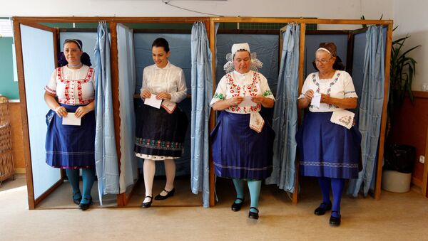 Hungarian women wearing traditional costume leave a voting booth at a polling station during a referendum on EU migrant quotas in Veresegyhaz, Hungary, October 2, 2016 - Sputnik International