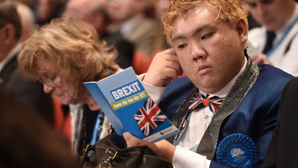 A delegate reads a leaflet entitled BREXIT, how do we do it? as he sits in the audience on the second day of the annual Conservative Party conference at the International Convention Centre in Birmingham, central England, on October 3, 2016. - Sputnik International
