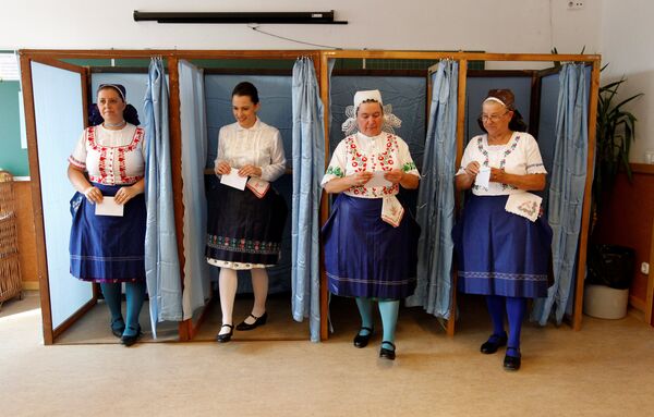 Hungarian women wearing traditional costume leave a voting booth at a polling station during a referendum on EU migrant quotas in Veresegyhaz, Hungary, October 2, 2016.  - Sputnik International