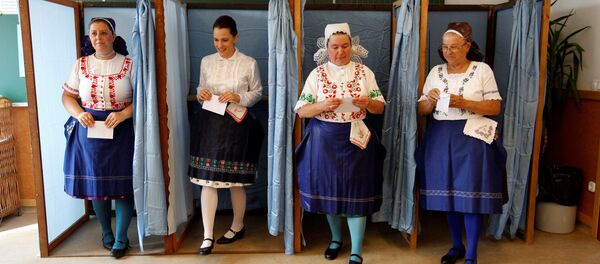 Hungarian women wearing traditional costume leave a voting booth at a polling station during a referendum on EU migrant quotas in Veresegyhaz, Hungary, October 2, 2016. Hungarian women wearing traditional costume leave a voting booth at a polling station during a referendum on EU migrant quotas in Veresegyhaz, Hungary, October 2, 2016. - Sputnik International
