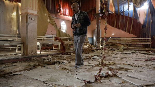 A man inspects the damage at a wedding hall a day after a suicide attack targeted a Kurdish wedding party in the village of Tall Tawil in the Syrian Hasakeh province - Sputnik International