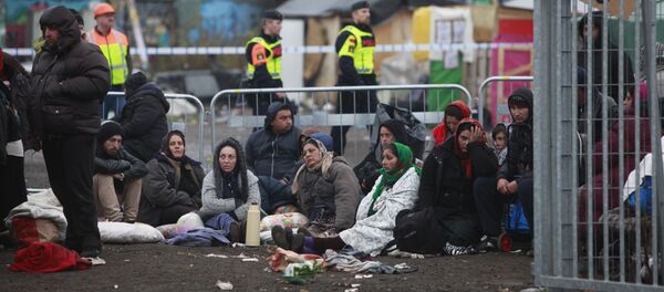 Migrants sit on the ground before leaving an illegal camp set up in Malmo (file) - Sputnik International