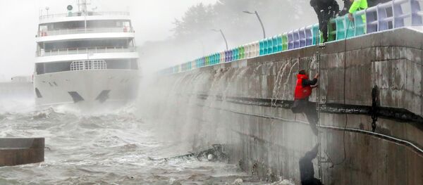 South Korean coast guards try to rescue crew members of a stranded passenger ship in the aftermath of typhoon Chaba in the southern city of Yeosu - Sputnik International