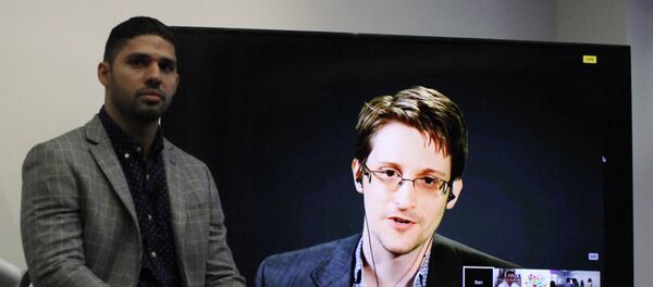 David Miranda (L) listens to American whistleblower Edward Snowden as he delivers remarks via video link from Moscow to attendees at a discussion regarding an International Treaty on the Right to Privacy, Protection Against Improper Surveillance and Protection of Whistleblowers in Manhattan in New York. (File) - Sputnik International