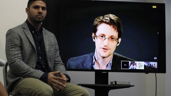 David Miranda (L) listens to American whistleblower Edward Snowden as he delivers remarks via video link from Moscow to attendees at a discussion regarding an International Treaty on the Right to Privacy, Protection Against Improper Surveillance and Protection of Whistleblowers in Manhattan in New York. (File) - Sputnik International