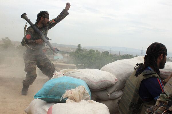 An Afghan National Army soldier, left, shouts against the Taliban, after firing a rocket towards Taliban positions, on the outskirts of Kunduz, northern Afghanistan (File) - Sputnik International