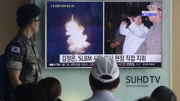 South Korean army soldier watches a TV news program showing images published in North Korea's Rodong Sinmun newspaper of North Korea's ballistic missile believed to have been launched from underwater and North Korean leader Kim Jong-un, at Seoul Railway station in Seoul, South Korea (File) - Sputnik International