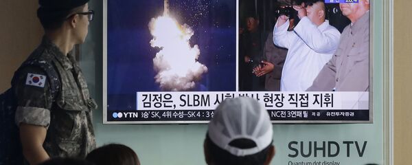 South Korean army soldier watches a TV news program showing images published in North Korea's Rodong Sinmun newspaper of North Korea's ballistic missile believed to have been launched from underwater and North Korean leader Kim Jong-un, at Seoul Railway station in Seoul, South Korea (File) - Sputnik International