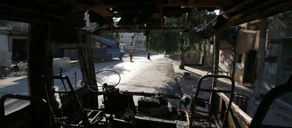 People walk past a burnt bus in the rebel held Seif al-Dawla neighbourhood of Aleppo, Syria October 6, 2016 People walk past a burnt bus in the rebel held Seif al-Dawla neighbourhood of Aleppo, Syria October 6, 2016 - Sputnik International
