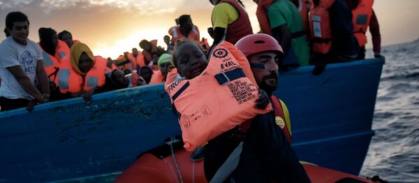 A child from African origin is rescued from a distressed vessel by a member of Proactiva Open Arms NGO in the mediteranean sea some 20 nautical miles north of Libya on October 3, 2016 A child from African origin is rescued from a distressed vessel by a member of Proactiva Open Arms NGO in the mediteranean sea some 20 nautical miles north of Libya on October 3, 2016 - Sputnik International