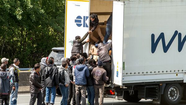 This file photo taken on June 23, 2015 shows migrants climbing in the back of a lorry on the A16 highway leading to the Eurotunnel in Calais, northern France - Sputnik International