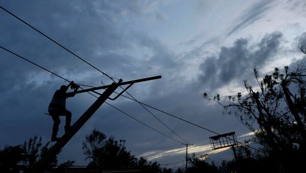 A worker for an electricity company fixes a power line affected by Hurricane Matthew on the outskirts of Les Cayes, Haiti, October 6, 2016 - Sputnik International