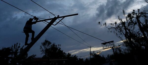 A worker for an electricity company fixes a power line affected by Hurricane Matthew on the outskirts of Les Cayes, Haiti, October 6, 2016 - Sputnik International