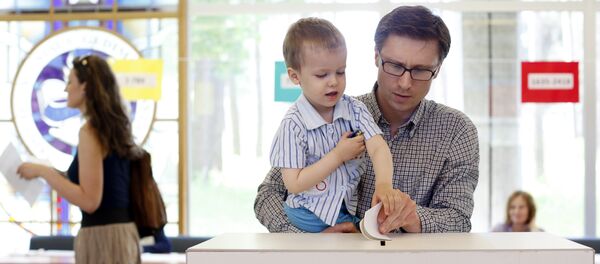 A man with a child casts his ballot during the elections in Vilnius, Lithuania (File) - Sputnik International