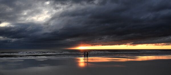 A couple watch the sunrise in Jacksonville Beach, Florida, on October 8, 2016, after Hurricane Matthew passed the area A couple watch the sunrise in Jacksonville Beach, Florida, on October 8, 2016, after Hurricane Matthew passed the area - Sputnik International