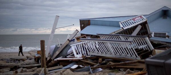 A police officer walks past the remnants of a home leveled by Hurricane Matthew after it hit the tiny beach community of Edisto Beach, S.C., Saturday, Oct. 8, 2016. - Sputnik International