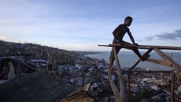 A resident works to repair his roof after it was ripped away by Hurricane Matthew in Jeremie, Haiti, Friday, Oct. 7, 2016 - Sputnik International