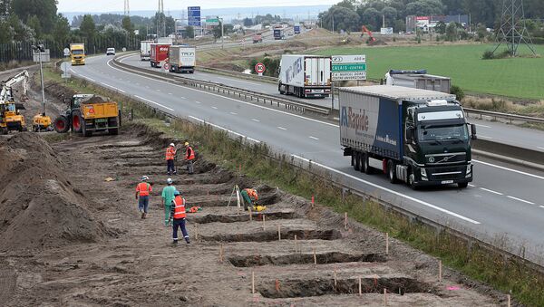 Workers begin construction of a 4-meter-high wall along the highway leading to the Calais port, outside Calais, northern France, Tuesday, Sept. 20, 2016 - Sputnik International