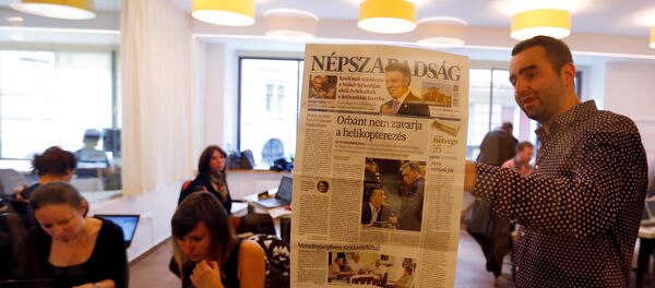 Journalists of the leftist newspaper Nepszabadsag, which was unexpectedly shut down on Saturday amid cries of a crackdown by right-wing Prime Minister Viktor Orban's government, paste a copy of the last issue onto the wall of a temporary newsroom in Budapest, Hungary, October 10, 2016 - Sputnik International