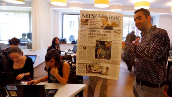 Journalists of the leftist newspaper Nepszabadsag, which was unexpectedly shut down on Saturday amid cries of a crackdown by right-wing Prime Minister Viktor Orban's government, paste a copy of the last issue onto the wall of a temporary newsroom in Budapest, Hungary, October 10, 2016 - Sputnik International