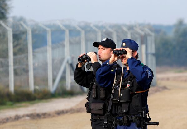 Hungarian and Polish policeman patrol at the Hungary and Serbia border fence near the village of Asotthalom, Hungary, October 2, 2016 as Hungarians vote in a referendum on the European Union's migrant quotas. Hungarian and Polish policeman patrol at the Hungary and Serbia border fence near the village of Asotthalom, Hungary, October 2, 2016 as Hungarians vote in a referendum on the European Union's migrant quotas. - Sputnik International