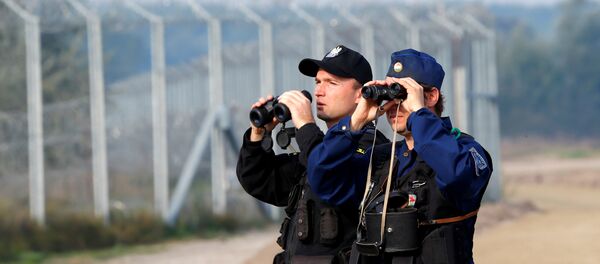 Hungarian and Polish policeman patrol at the Hungary and Serbia border fence near the village of Asotthalom, Hungary, October 2, 2016 as Hungarians vote in a referendum on the European Union's migrant quotas. Hungarian and Polish policeman patrol at the Hungary and Serbia border fence near the village of Asotthalom, Hungary, October 2, 2016 as Hungarians vote in a referendum on the European Union's migrant quotas. - Sputnik International