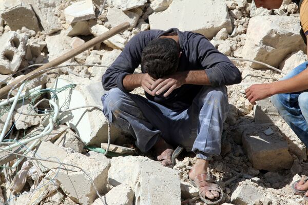 A man reacts on the rubble of damaged buildings after losing relatives to an airstrike in the besieged rebel-held al-Qaterji neighbourhood of Aleppo, Syria October 11, 2016. A man reacts on the rubble of damaged buildings after losing relatives to an airstrike in the besieged rebel-held al-Qaterji neighbourhood of Aleppo, Syria October 11, 2016. - Sputnik International