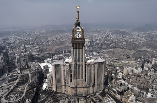 An aerial view shows the clock of the Abraj Al-Bait Towers, a government-owned mega-complex of seven skyscraper hotels in Saudi Arabia’s holy city of Mecca. The central hotel tower, the Makkah Royal Clock Tower, a Fairmont Hotel, has the world's largest clock face and is one of the tallest structures in the world, with a height of 581.1 meters. - Sputnik International