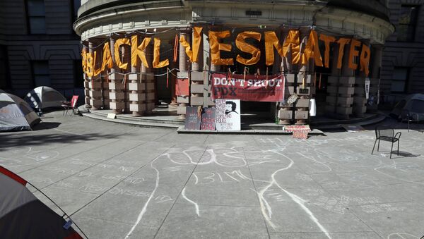 A raised raised is crawled in chalk as large letters saying Black Lives Matter hang on the portico at City Hall after the building was shut down due to a protest in Portland, Ore., Wednesday, Oct. 12, 2016. - Sputnik International