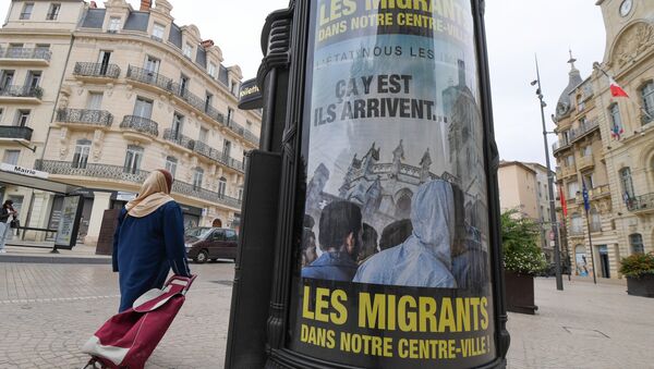 A woman walks by a poster reading They are coming, Migrants in our town centre in a street of Beziers, southern France, on October 12, 2016. - Sputnik International