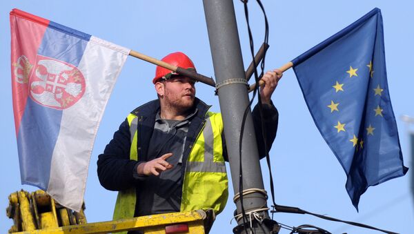 A worker arranges flags of Serbia and EU on a lamppost in Belgrade (File) - Sputnik International