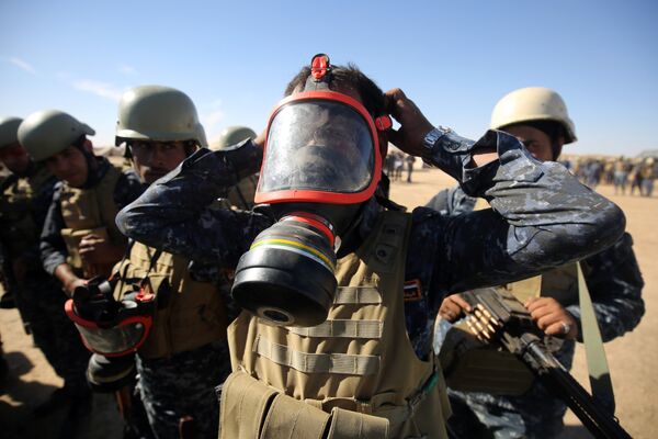 An Iraqi policeman tries on a gasmask at the Qayyarah military base, about 60 kilometres (35 miles) south of Mosul, on October 16, 2016, as they prepare for an offensive to retake Mosul An Iraqi policeman tries on a gasmask at the Qayyarah military base, about 60 kilometres (35 miles) south of Mosul, on October 16, 2016, as they prepare for an offensive to retake Mosul - Sputnik International
