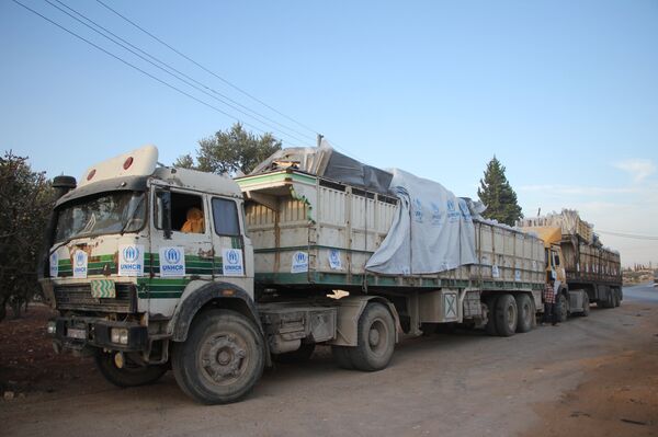 Trucks carrying aid are seen on the side of the road in the town of Orum al-Kubra on the western outskirts of the northern Syrian city of Aleppo on September 20, 2016 - Sputnik International