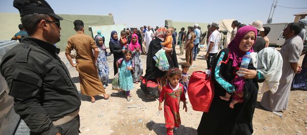 Iraqi security keep watch as civilians arrive on July 27, 2016 at a camp for displaced people in the district of Hajaj after fleeing the towns of al-Shirqat and Qayyarah, south of the city of Mosul, during reported fighting between Iraqi security forces and jihadists from the Islamic State (IS) grou Iraqi security keep watch as civilians arrive on July 27, 2016 at a camp for displaced people in the district of Hajaj after fleeing the towns of al-Shirqat and Qayyarah, south of the city of Mosul, during reported fighting between Iraqi security forces and jihadists from the Islamic State (IS) grou - Sputnik International