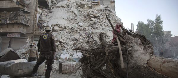 A member of the Syrian Civil Defence, known as the White Helmets, stands amid the rubble of a destroyed building during a rescue operation following reported air strikes in the rebel-held Qatarji neighbourhood of the northern city of Aleppo, on October 17, 2016 A member of the Syrian Civil Defence, known as the White Helmets, stands amid the rubble of a destroyed building during a rescue operation following reported air strikes in the rebel-held Qatarji neighbourhood of the northern city of Aleppo, on October 17, 2016 - Sputnik International