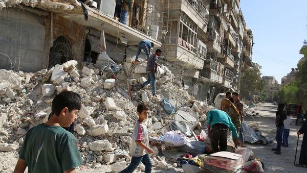 People remove belongings from a damaged site after an air strike Sunday in the rebel-held besieged al-Qaterji neighbourhood of Aleppo, Syria October 17, 2016 - Sputnik International