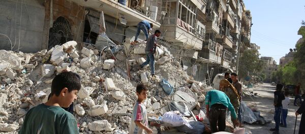 People remove belongings from a damaged site after an air strike Sunday in the rebel-held besieged al-Qaterji neighbourhood of Aleppo, Syria October 17, 2016 People remove belongings from a damaged site after an air strike Sunday in the rebel-held besieged al-Qaterji neighbourhood of Aleppo, Syria October 17, 2016 - Sputnik International