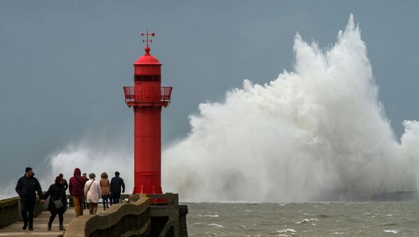 A wave breaks against a pier in front of a lighthouse in Boulogne-sur-Mer. - Sputnik International